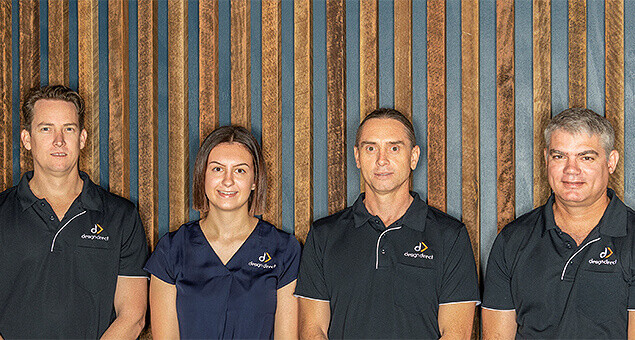 Design Direct leadership team standing against timber backdrop