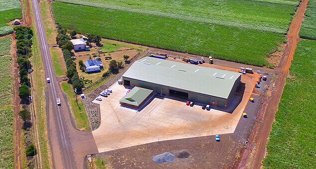 Aerial view of large farming production shed surrounded by farmland