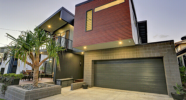 Custom modern home at dusk with lights on