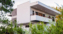 Home designed by Design Direct seen through green shrubbery